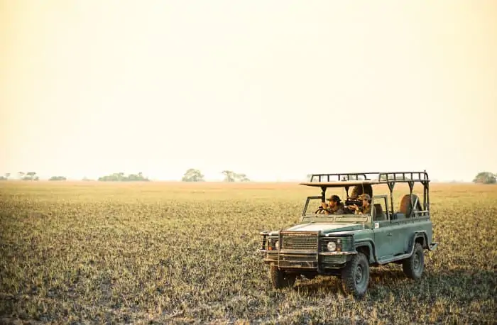 Game drive vehicle at sunset in Kafue National Park