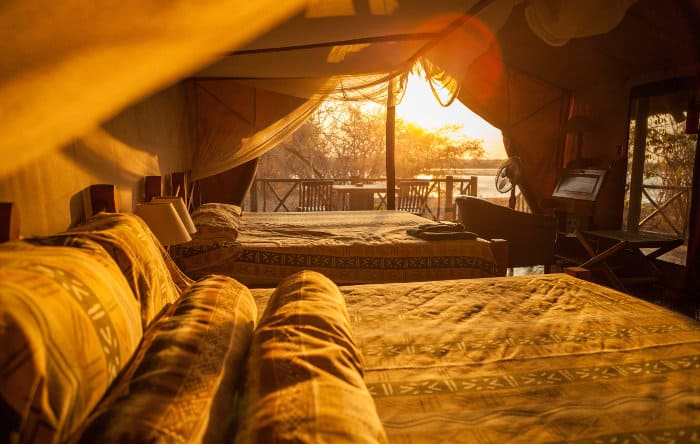 Inside a luxury safari tent, with private balcony overlooking the river