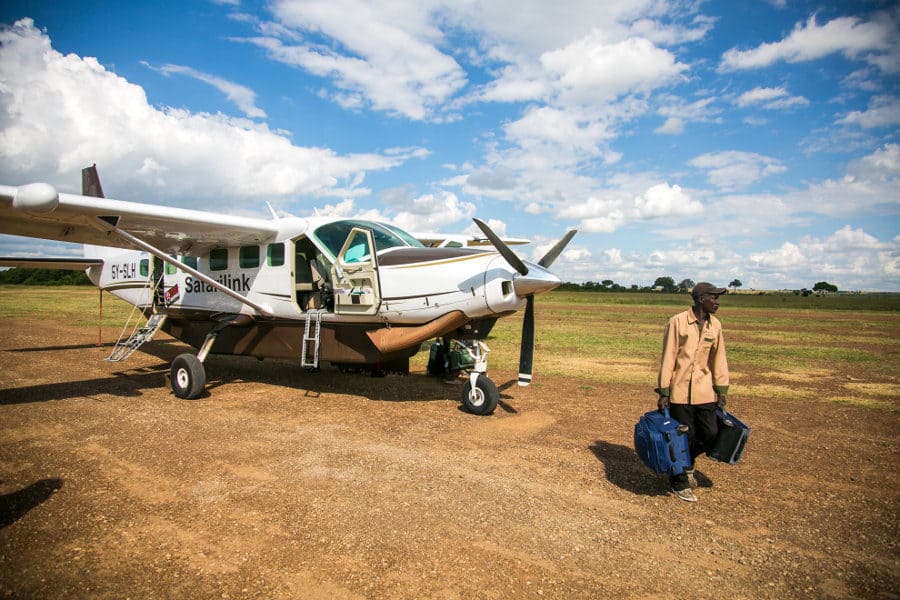 Unloading safari luggage from a small plane at the Maasai Mara airstrip