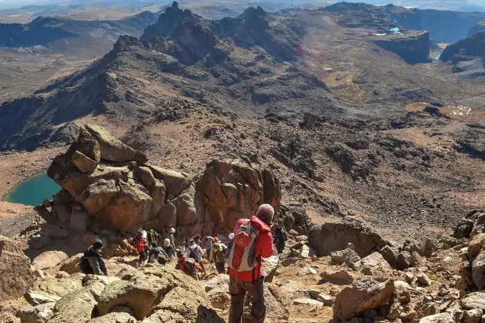 Hikers progressing on Mount Kenya's volcanic landscape
