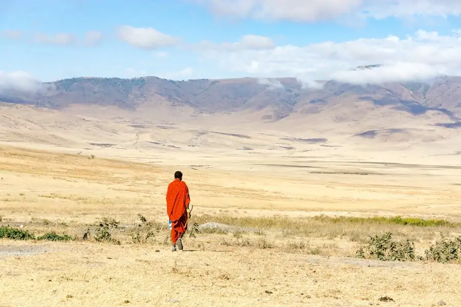 Lone Maasai herdsman walking on the endless African plains