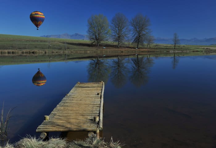 Hot air balloon rising above Himeville in the Southern Drakensberg Mountains