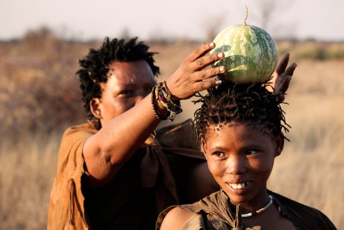 Smiling San woman with a Tsamma melon on her head