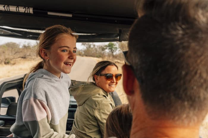 Young girl with a huge smile enjoys her game drive in the Kruger